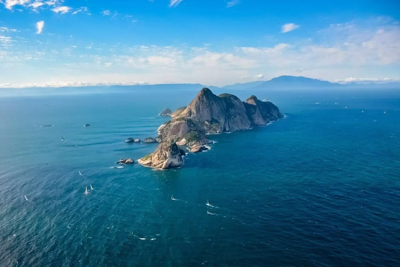 Pico do arquipélago de Alcatrazes com veleiros ao redor
