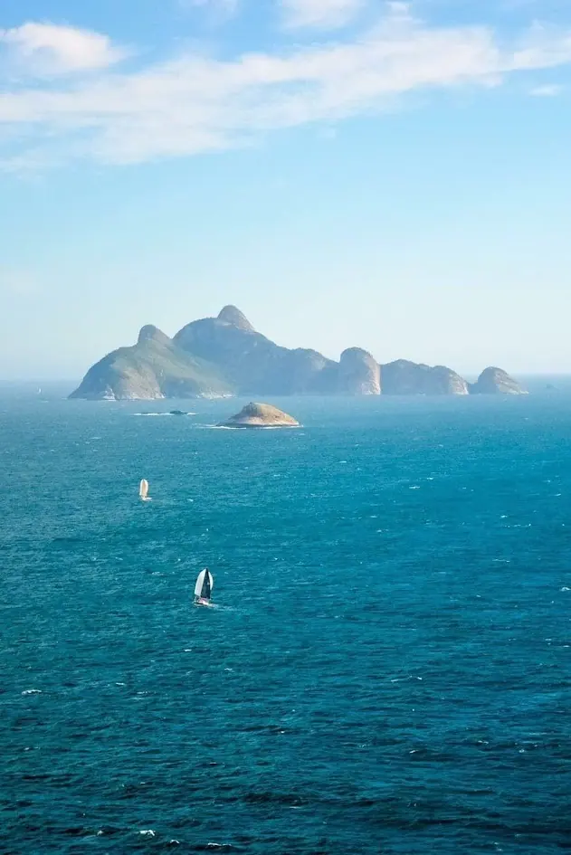 Arquipélago de Alcatrazes visto do mar, com veleiros ao redor