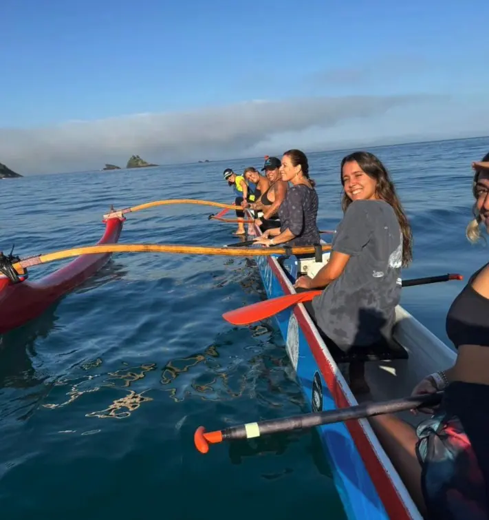 Grupo remando de canoa havaiana em mar calmo no litoral norte