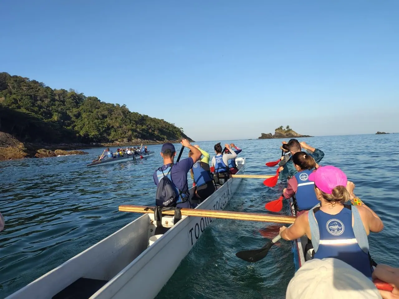 Canoa havaiana remando em direção a uma pequena ilha da Costa Sul