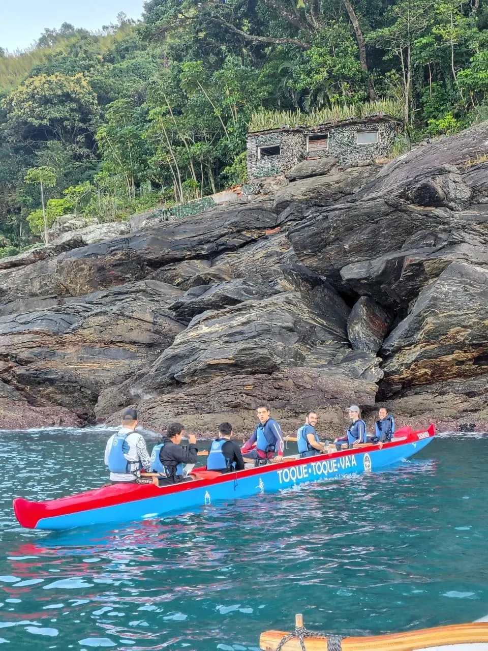 Canoa havaiana vermelha junto ao costão perto de Toque-Toque Pequeno