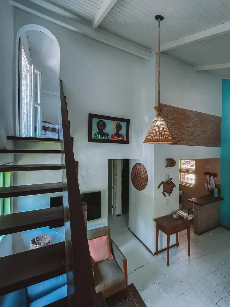 Sala da Casa 1 Praia, com escada de madeira e decoração caiçara