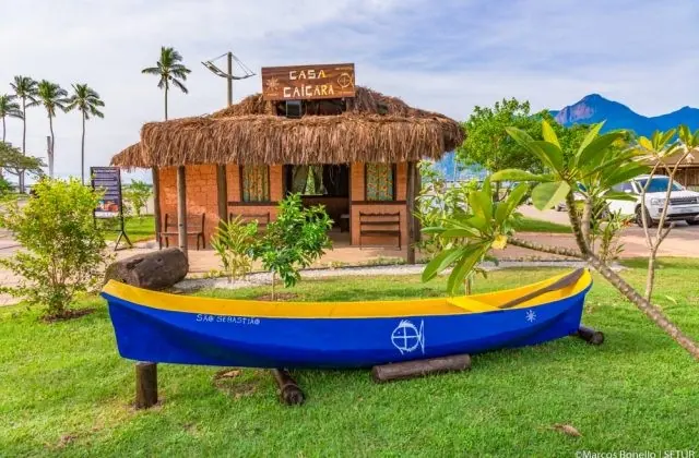 Casa Caiçara de São Sebastião, com uma canoa colorida no jardim