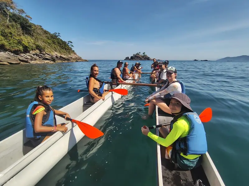 Crianças e adultos remando a canoa havaiana em Toque-Toque Pequeno