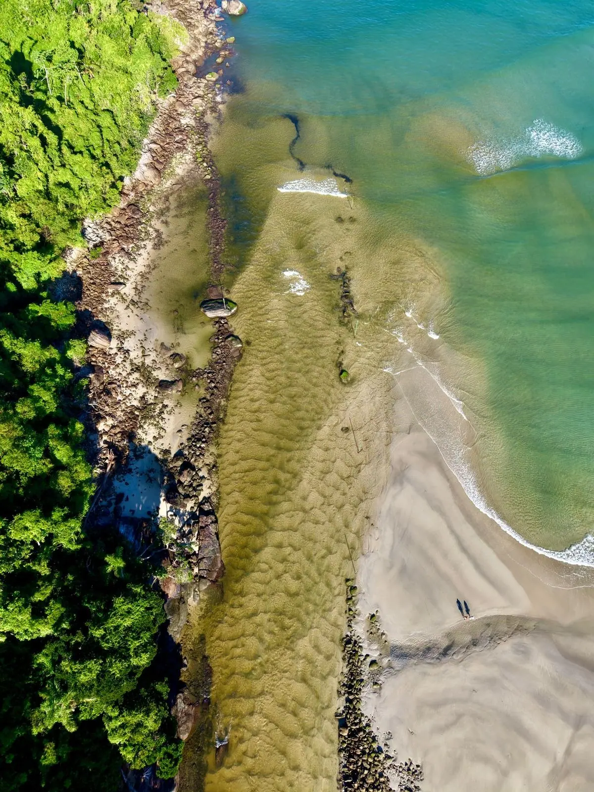 Ilha com faixa de areia e água rasa vista do alto