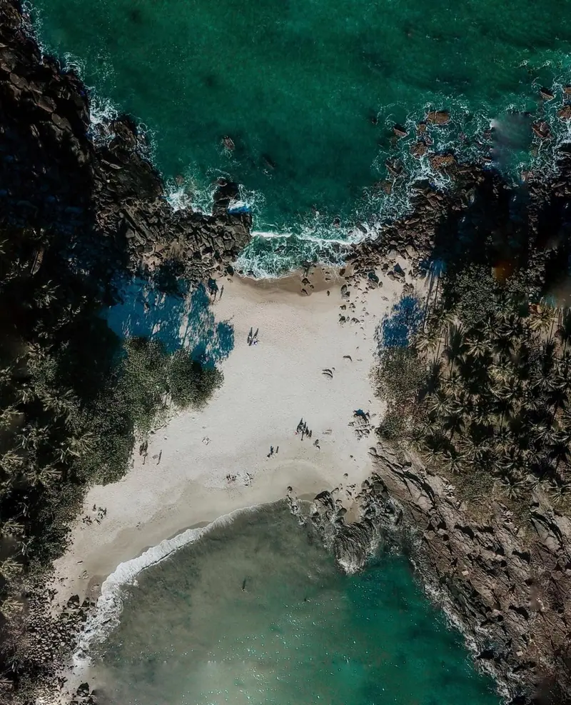 Vista aérea da península de Calhetas, com as duas faixas de areia entre os costões