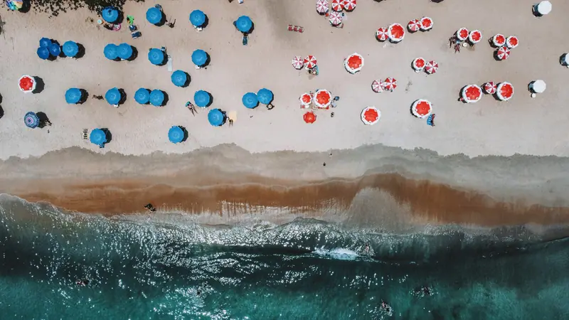 Vista aérea da Praia de Santiago com guarda-sóis coloridos na areia