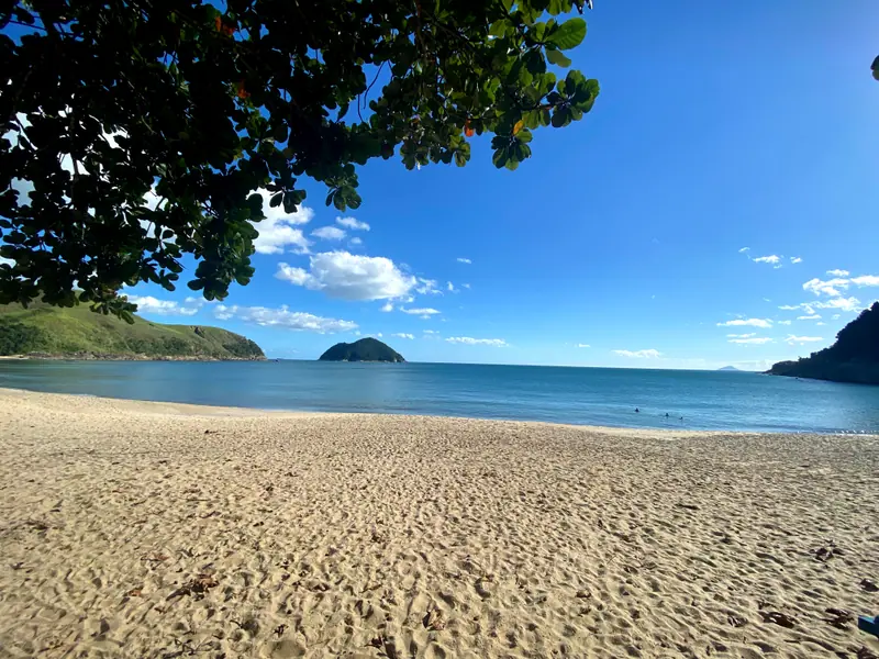 Areia de Toque-Toque Grande à sombra de uma árvore, com a ilha no horizonte