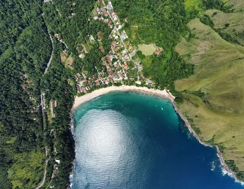 Vista aérea vertical da enseada de Toque-Toque Grande, com a vila entre a mata e o mar