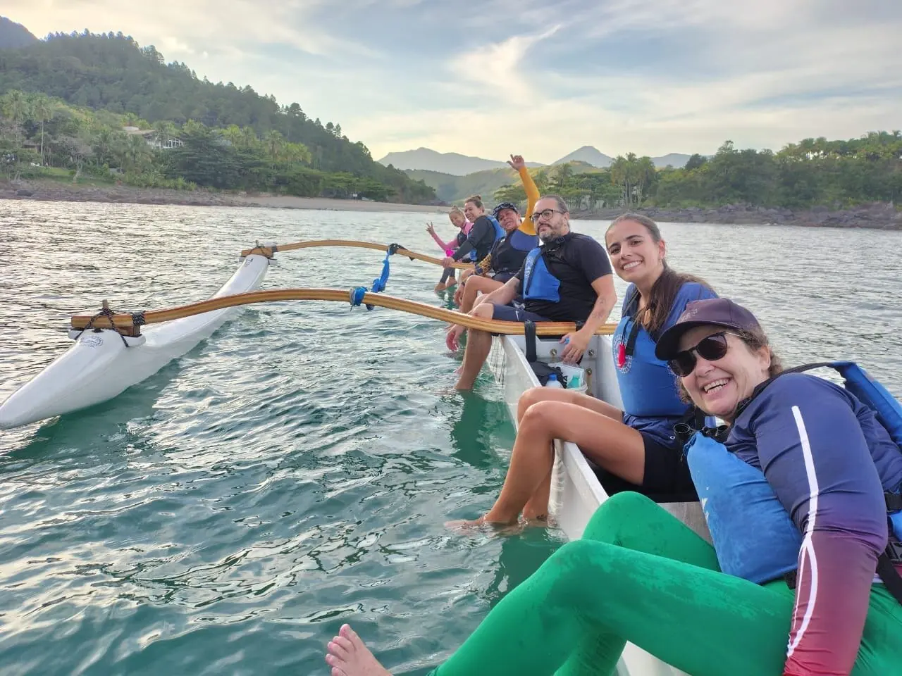 Remadoras sorrindo na canoa havaiana ao entardecer
