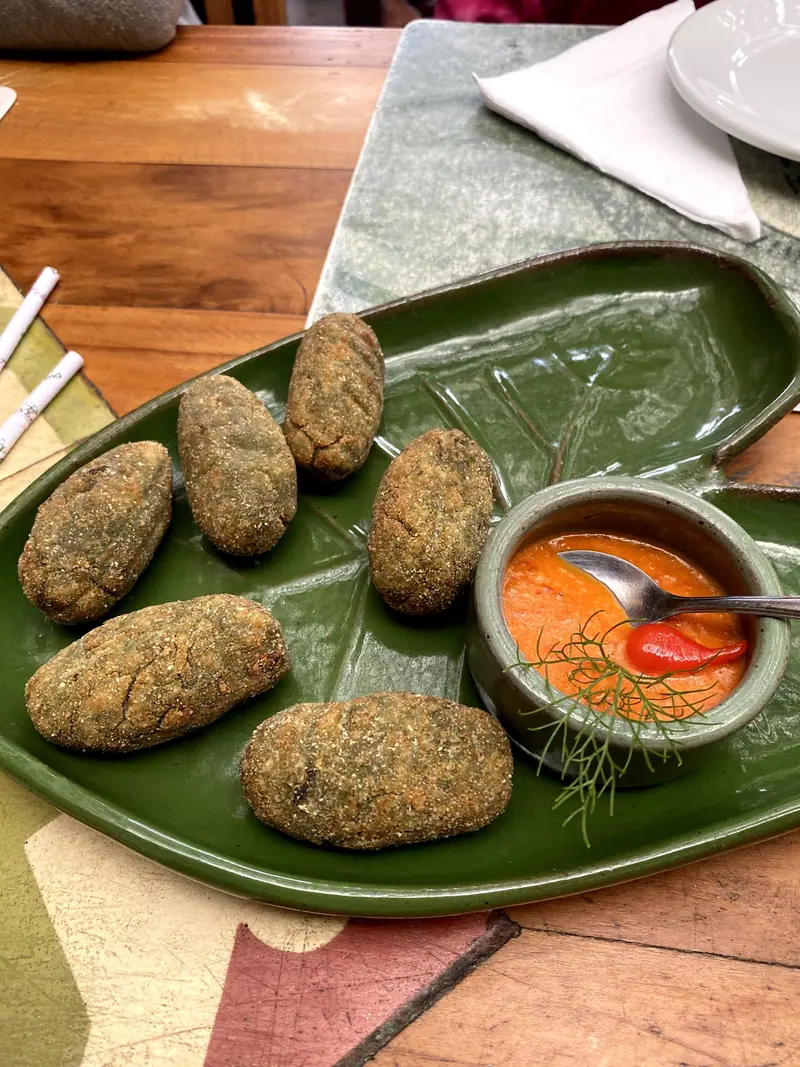 Bolinhos de taioba empanados servidos com molho no restaurante Taioba, em Camburi