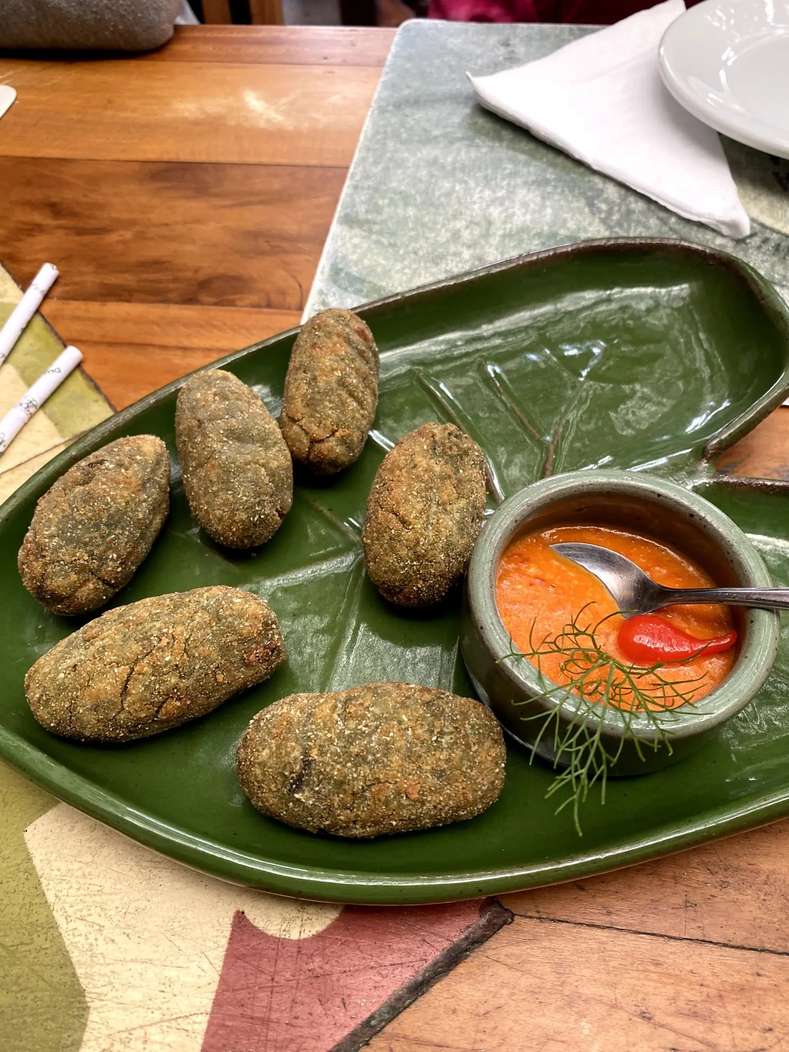 Bolinhos de taioba empanados servidos com molho no restaurante Taioba, em Camburi