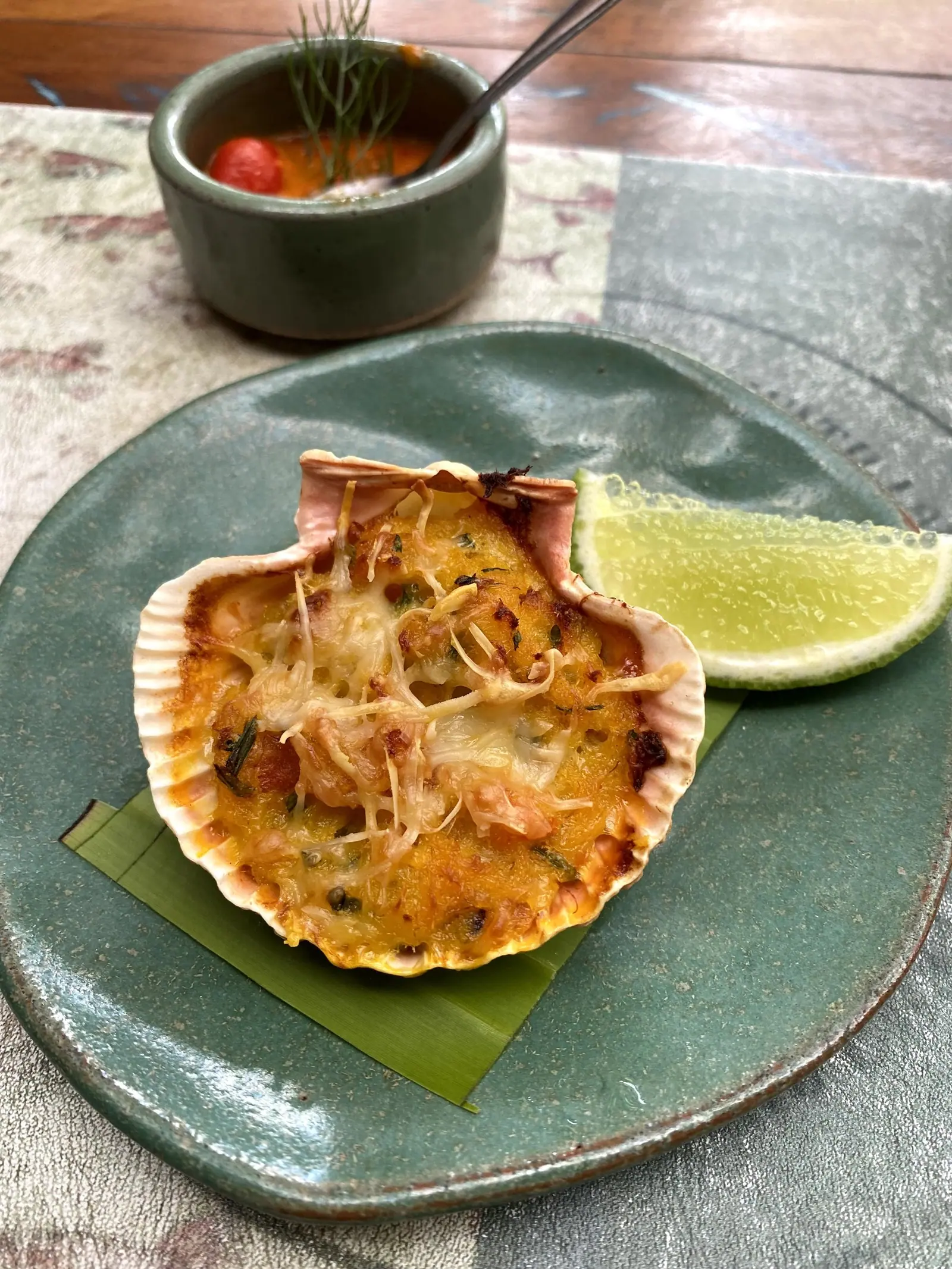 Casquinha gratinada servida na concha com limão no Taioba