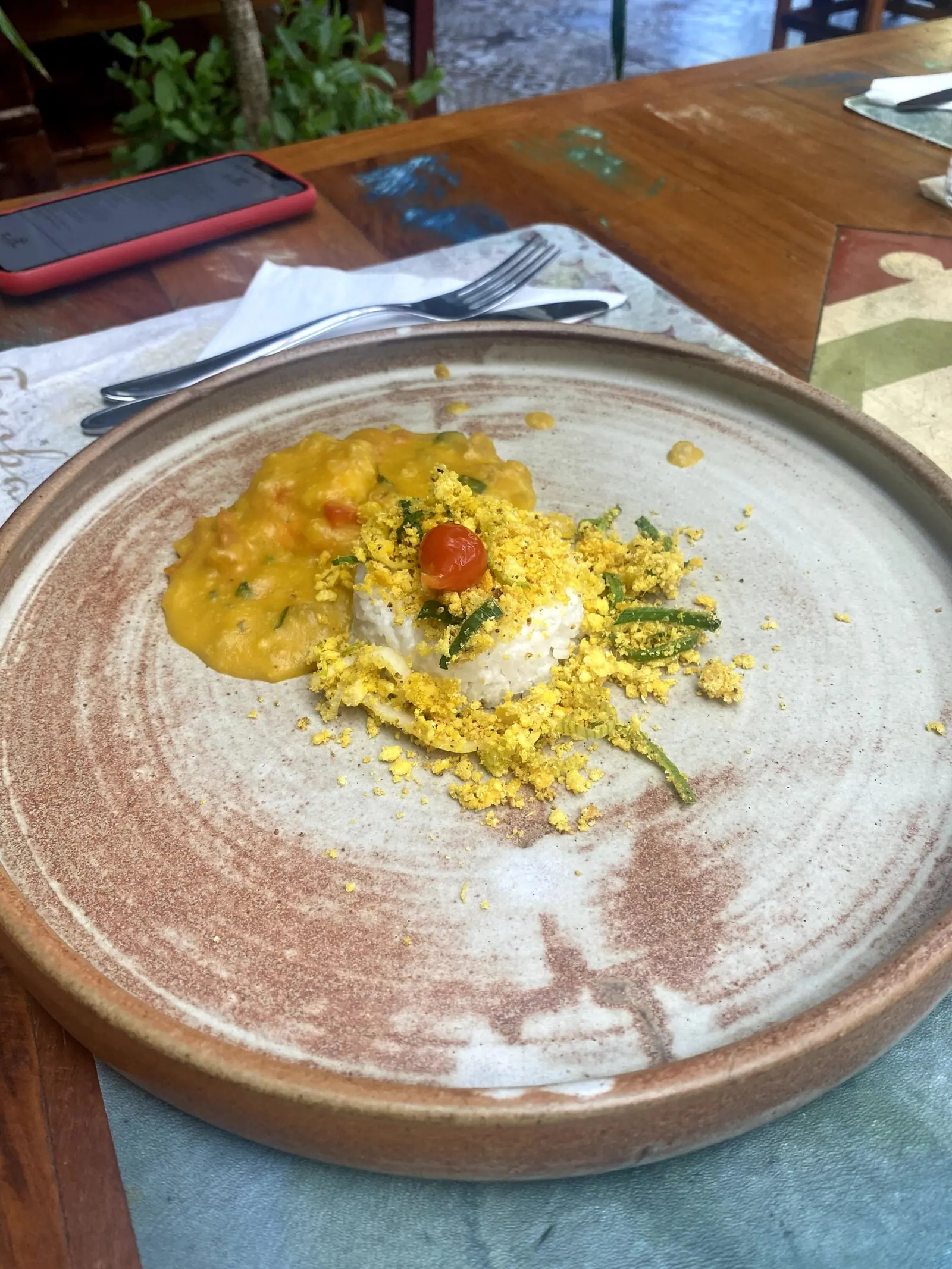Prato do dia com arroz, molho e farofa de ovo servido em cerâmica artesanal no Taioba