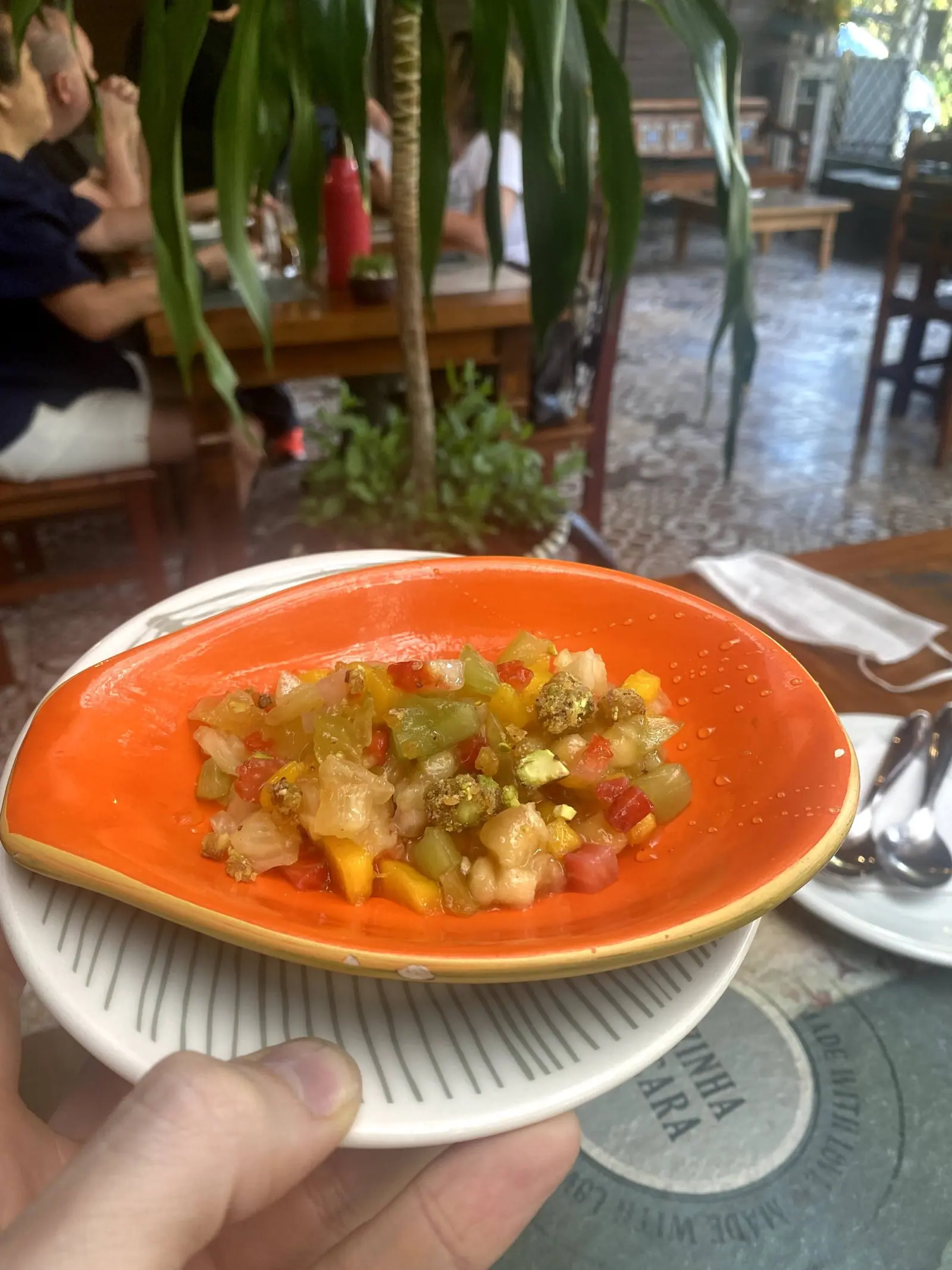 Salada tropical de frutas picadas servida em prato laranja no Taioba
