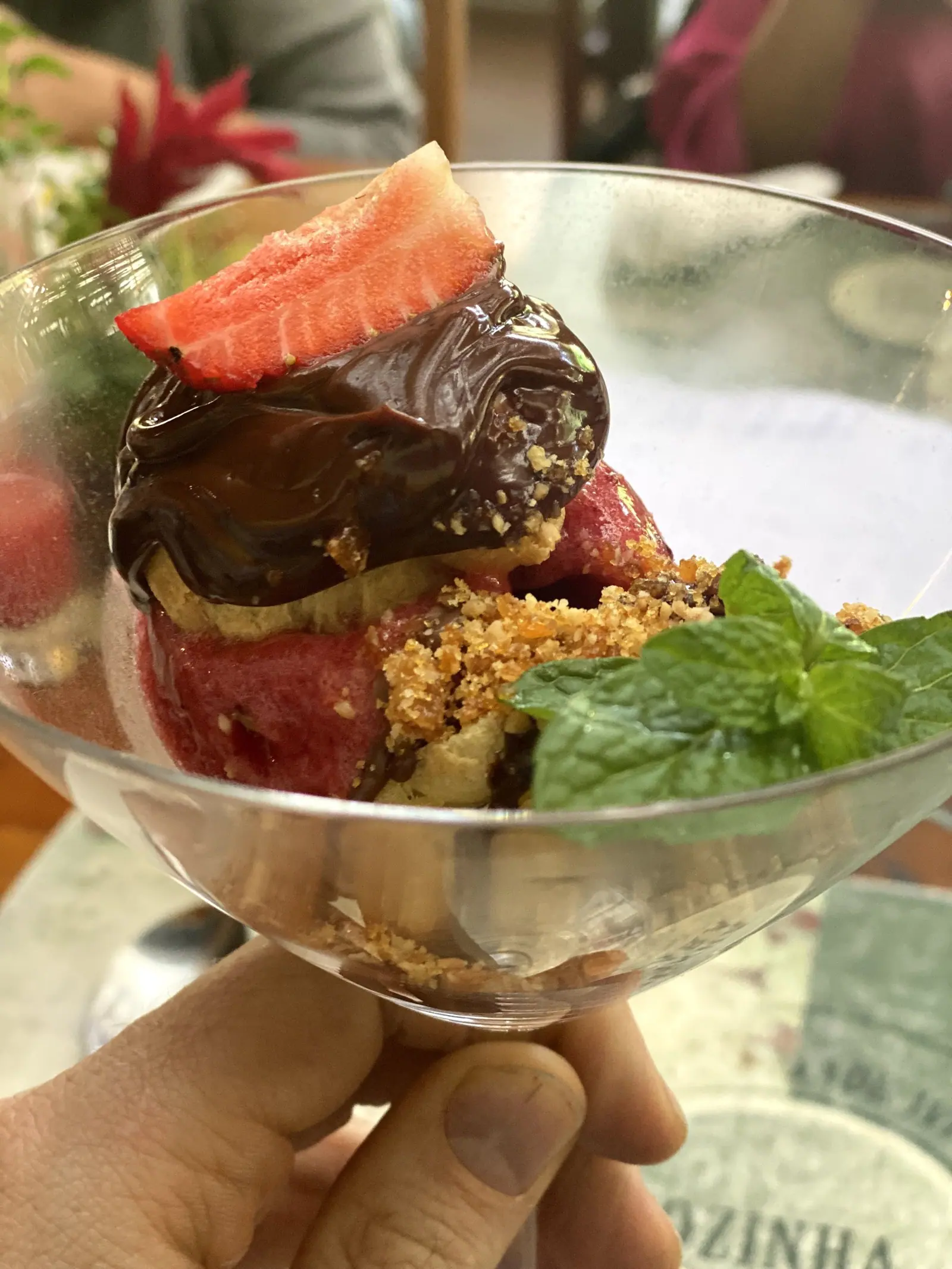 Taça de sobremesa com chocolate, morango, farofa doce e hortelã no Taioba