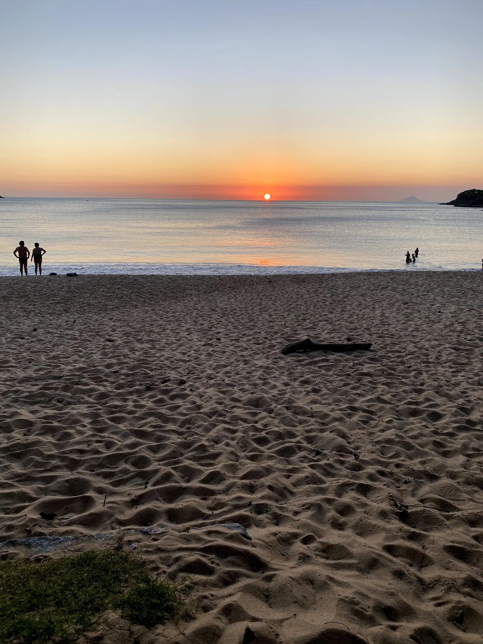 Areia de Toque-Toque Grande com banhistas ao pôr do sol