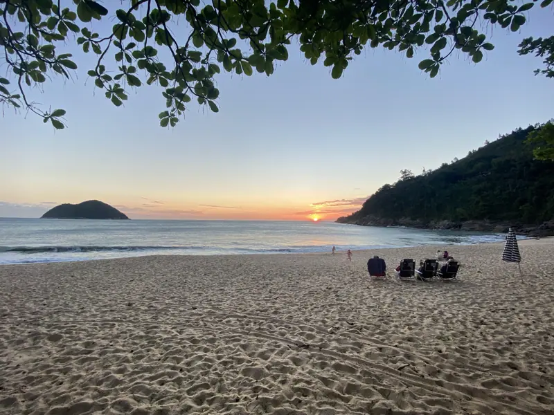 Família sentada em cadeiras de praia na areia de Toque-Toque Grande no fim da tarde