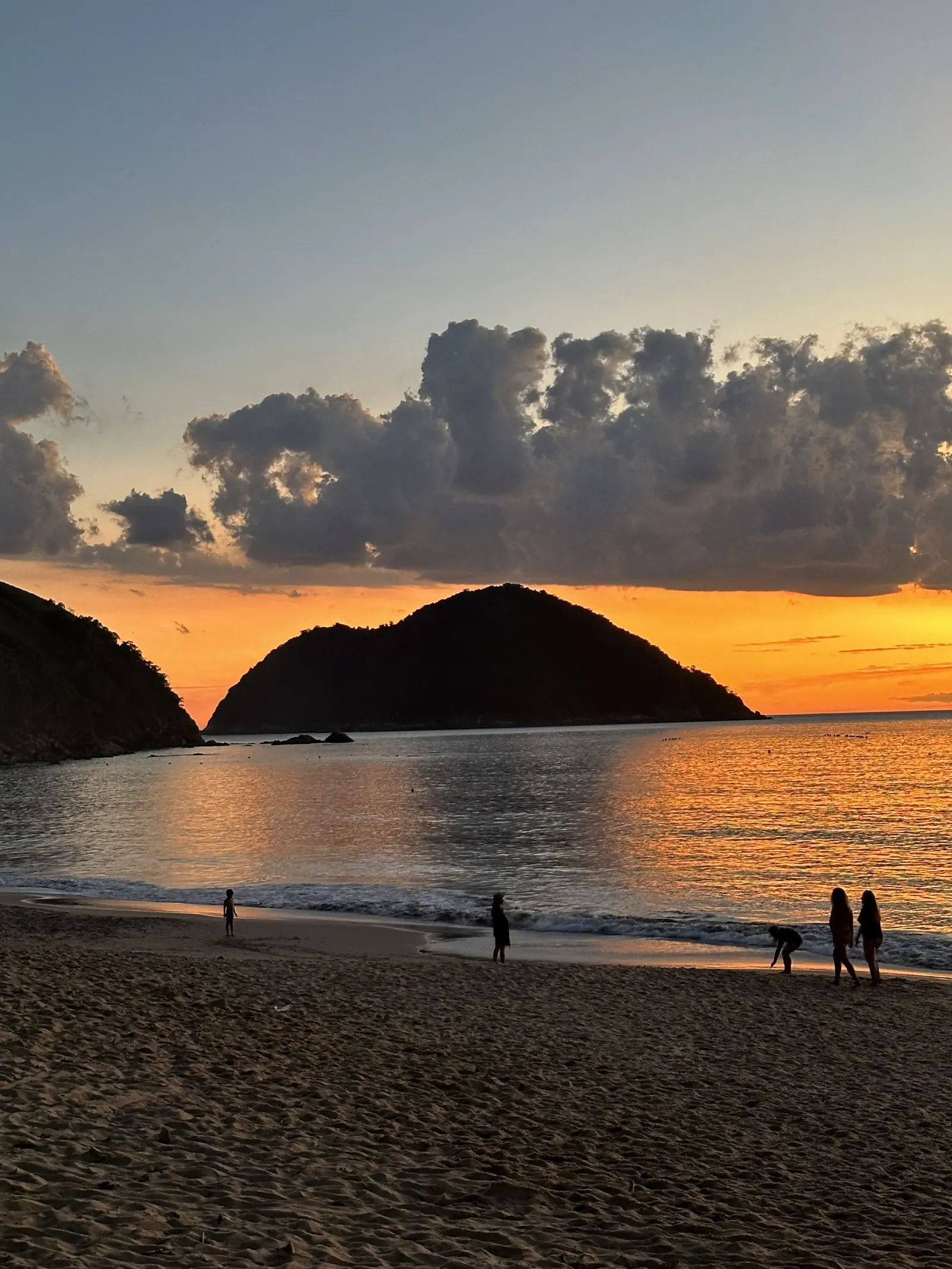 Ilha de Toque-Toque Grande e banhistas na areia no fim da tarde