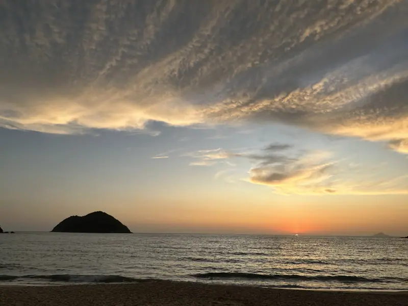 Ilha em frente a Toque-Toque Grande sob um céu de nuvens riscadas no entardecer