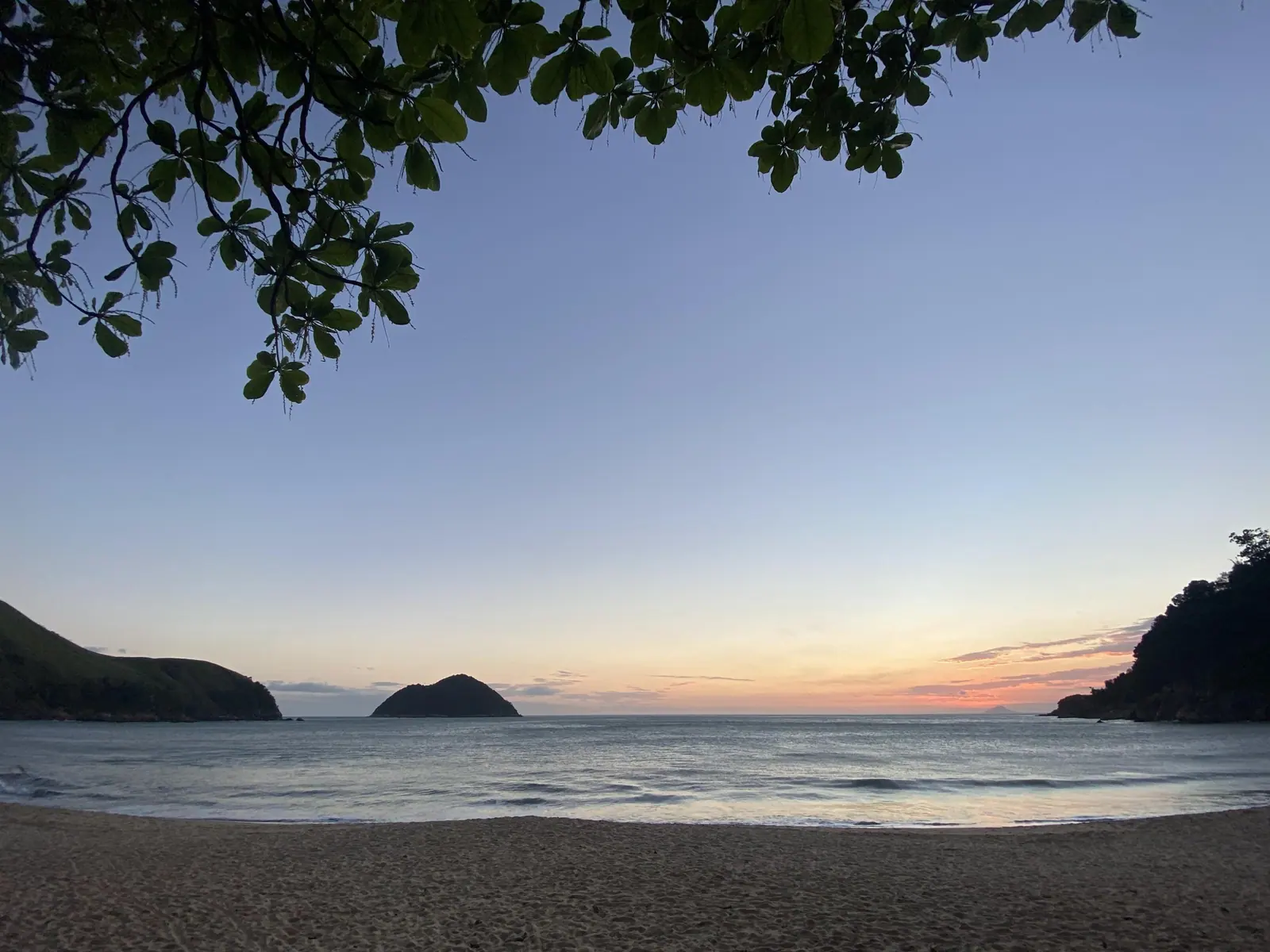Ilha e costão de Toque-Toque Grande ao anoitecer, vistos da areia