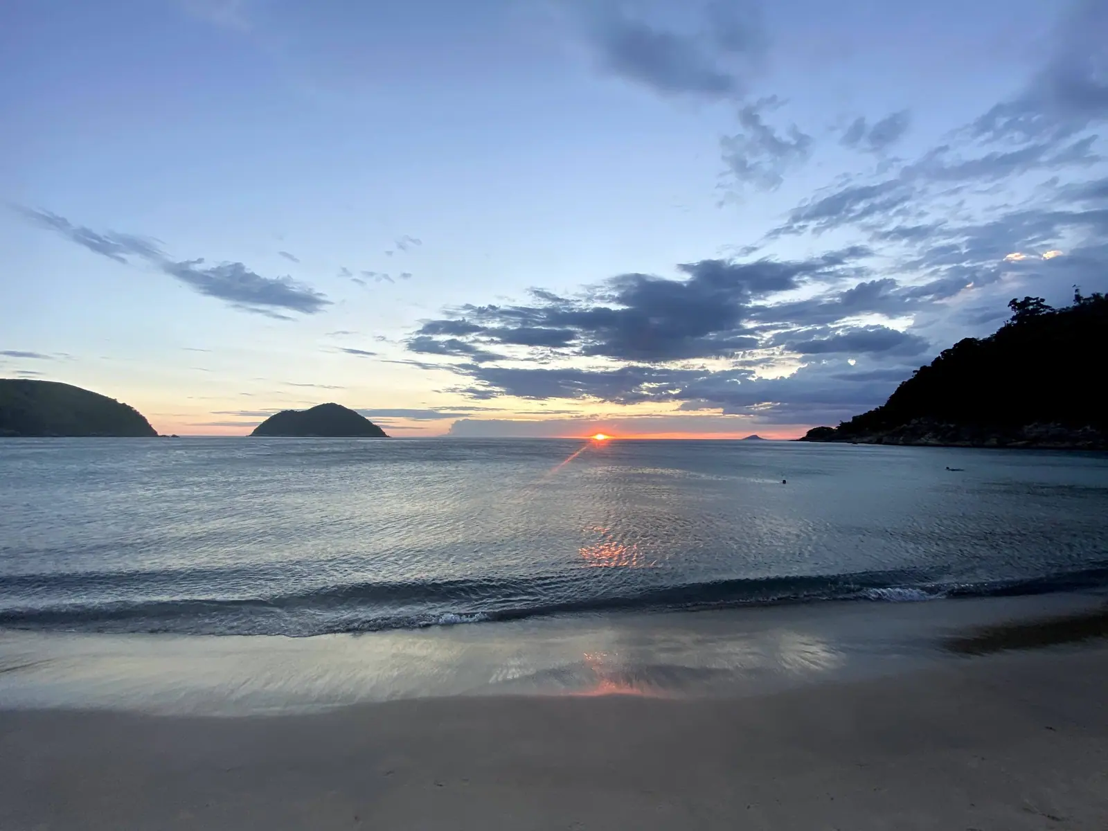 Mar calmo de Toque-Toque Grande com duas ilhas e o costão