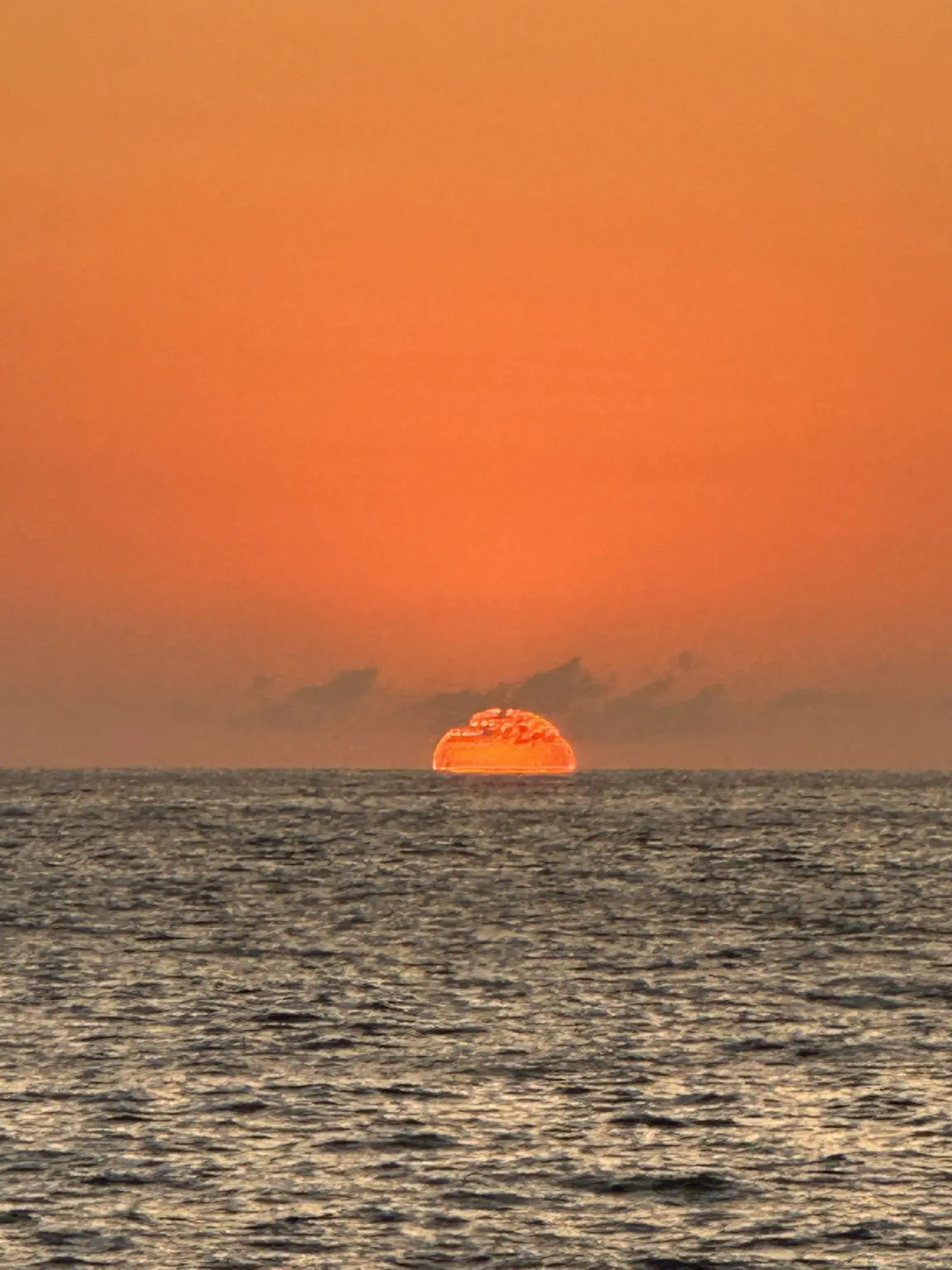 Metade do sol mergulhando no mar de Toque-Toque Grande