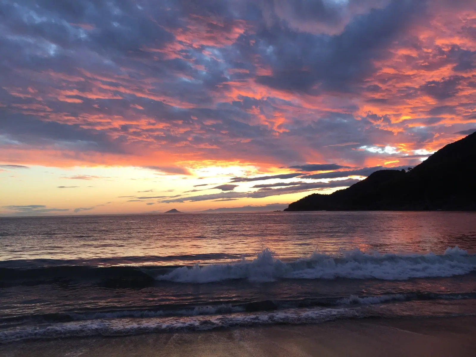 Ondas quebrando em Toque-Toque Grande sob um céu rosa