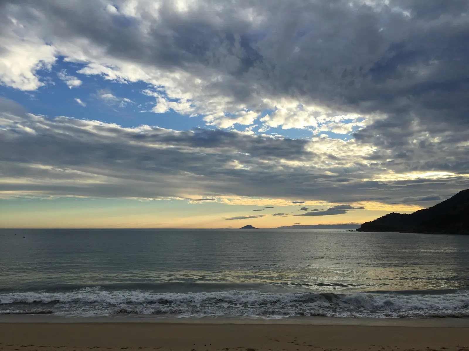 Tarde de tempo virando em Toque-Toque Grande, com nuvens carregadas sobre o mar