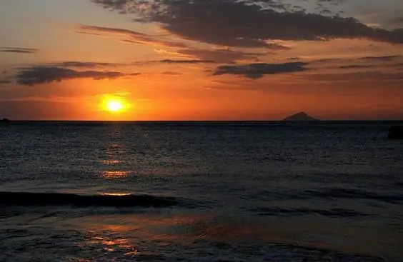 Pôr do sol sobre o mar com uma ilha no horizonte, visto de Toque-Toque Pequeno