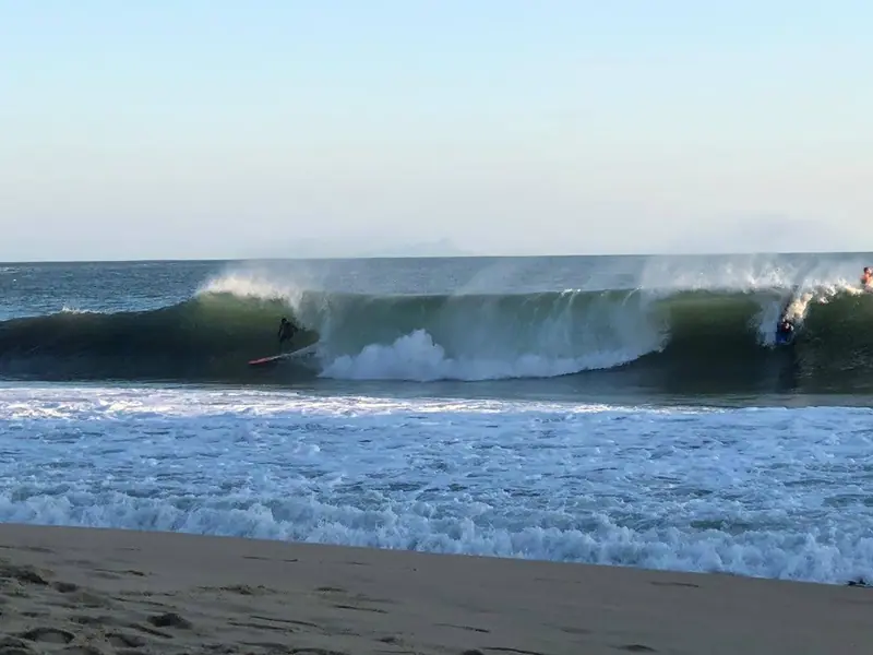 Tubo gigante quebrando perto da areia na Praia de Paúba em dia de ondulação de sul