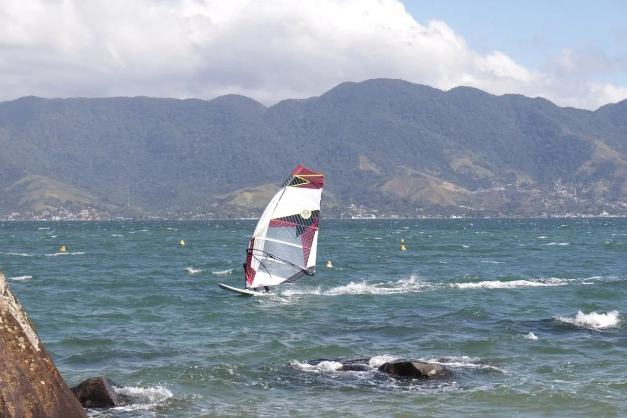 Windsurfista velejando perto do costão em Ilhabela